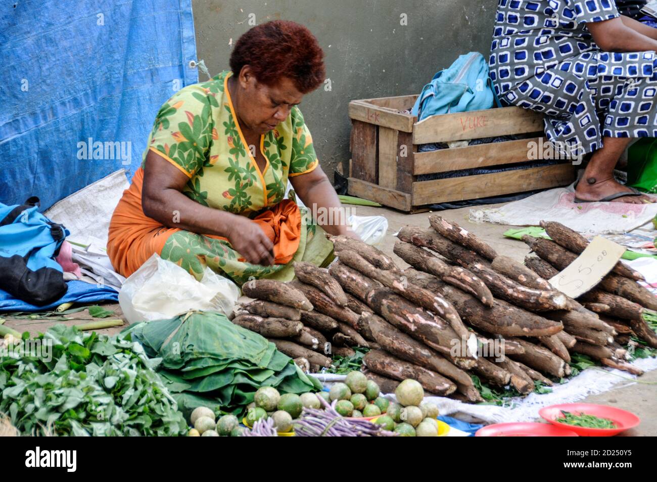 A street vendor selling  Casava, a national Fiji root crop  at a fruit & veg market in Sigatoka on Viti Levu, Fiji. The Casava is  boiled and served w Stock Photo