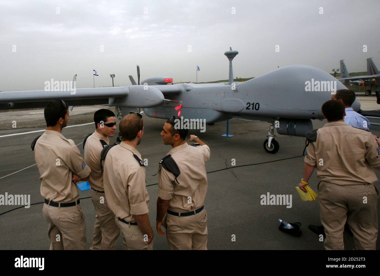 Israeli soldiers look at an IAI Eitan, also known as the Heron TP, surveillance unmanned air vehicle (UAV) on display at Tel Nof Air Force Base near Tel Aviv February 21, 2010. An Israeli air force officer said the Israeli-made drone is larger than any other drone and can fly at higher altitudes, while carrying more weight including advanced technological systems. The officer said the drone's main advantage was its longer flying time, estimated at 20 hours. REUTERS/Gil Cohen Magen (ISRAEL - Tags: TRANSPORT MILITARY) Stock Photo