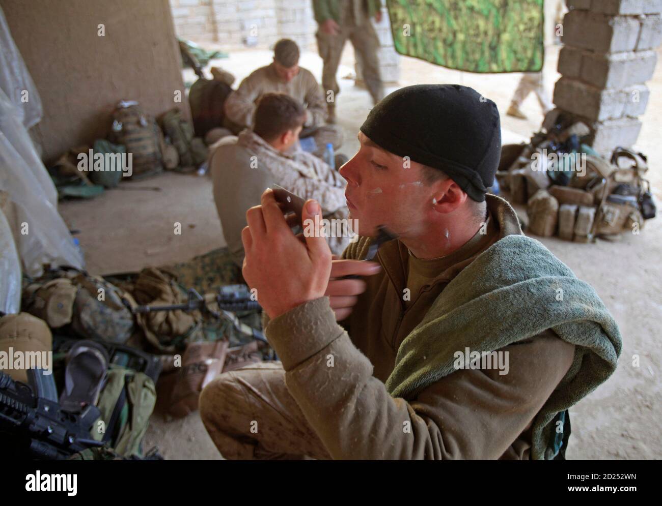 A U.S. Marine from Bravo Company of the 1st Battalion, 6th Marines shaves at early morning in Marjah, Helmand province, southern Afghanistan February 25, 2010.   REUTERS/Goran Tomasevic  (AFGHANISTAN - Tags: MILITARY POLITICS) Stock Photo