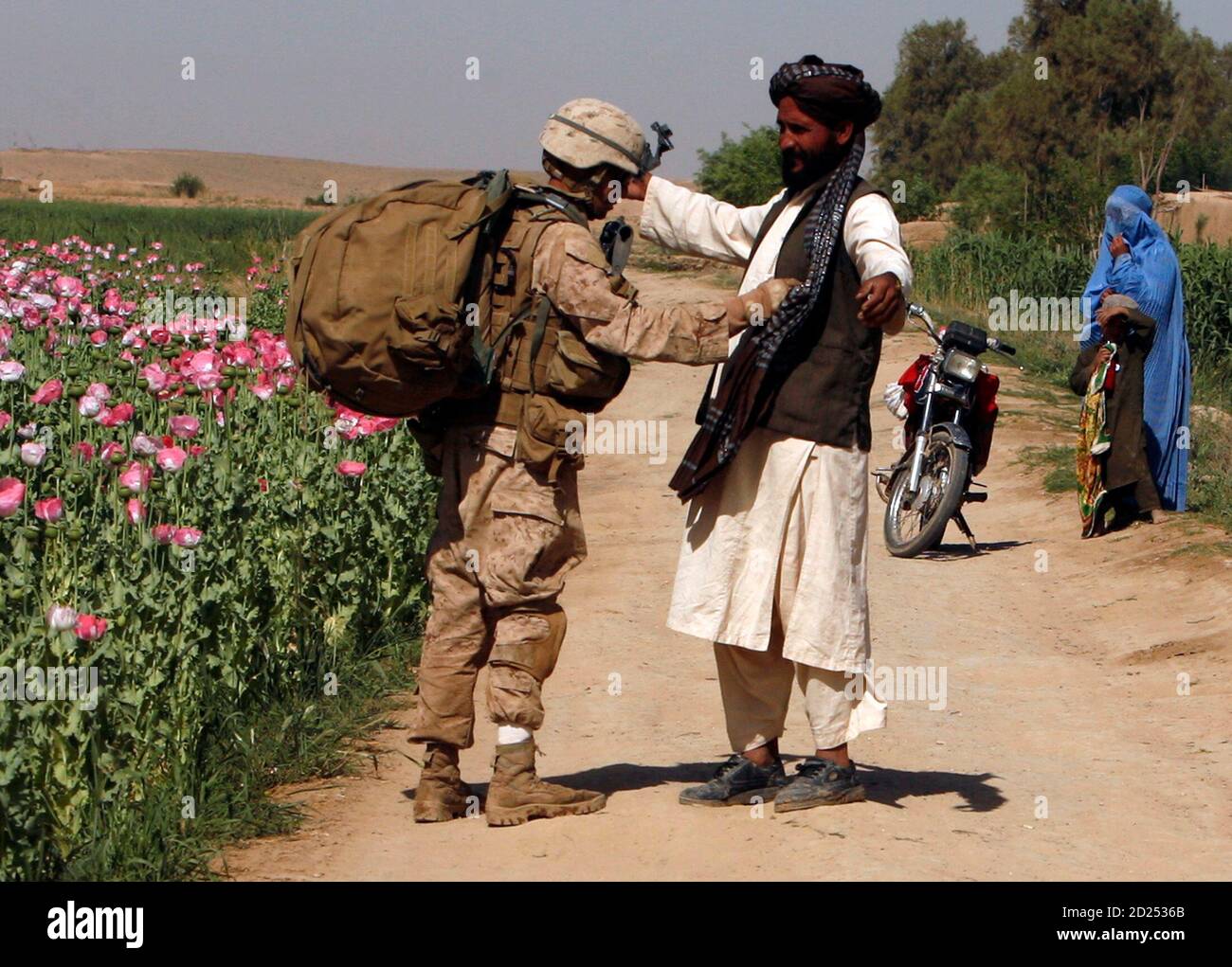A U.S. Marine from Lima company 3rd Battalion 6th Marine Regiment searches an Afghan man as they patrol in Karez-e-Sayyidi, in Helmand province, April 5, 2010. REUTERS/Asmaa Waguih  (AFGHANISTAN - Tags: CIVIL UNREST MILITARY CONFLICT) Stock Photo