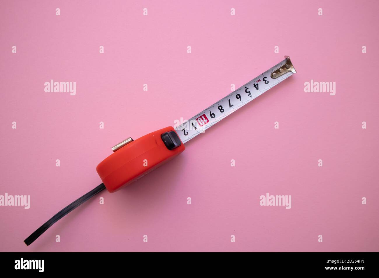 Red measuring tape on pink background, top view Stock Photo