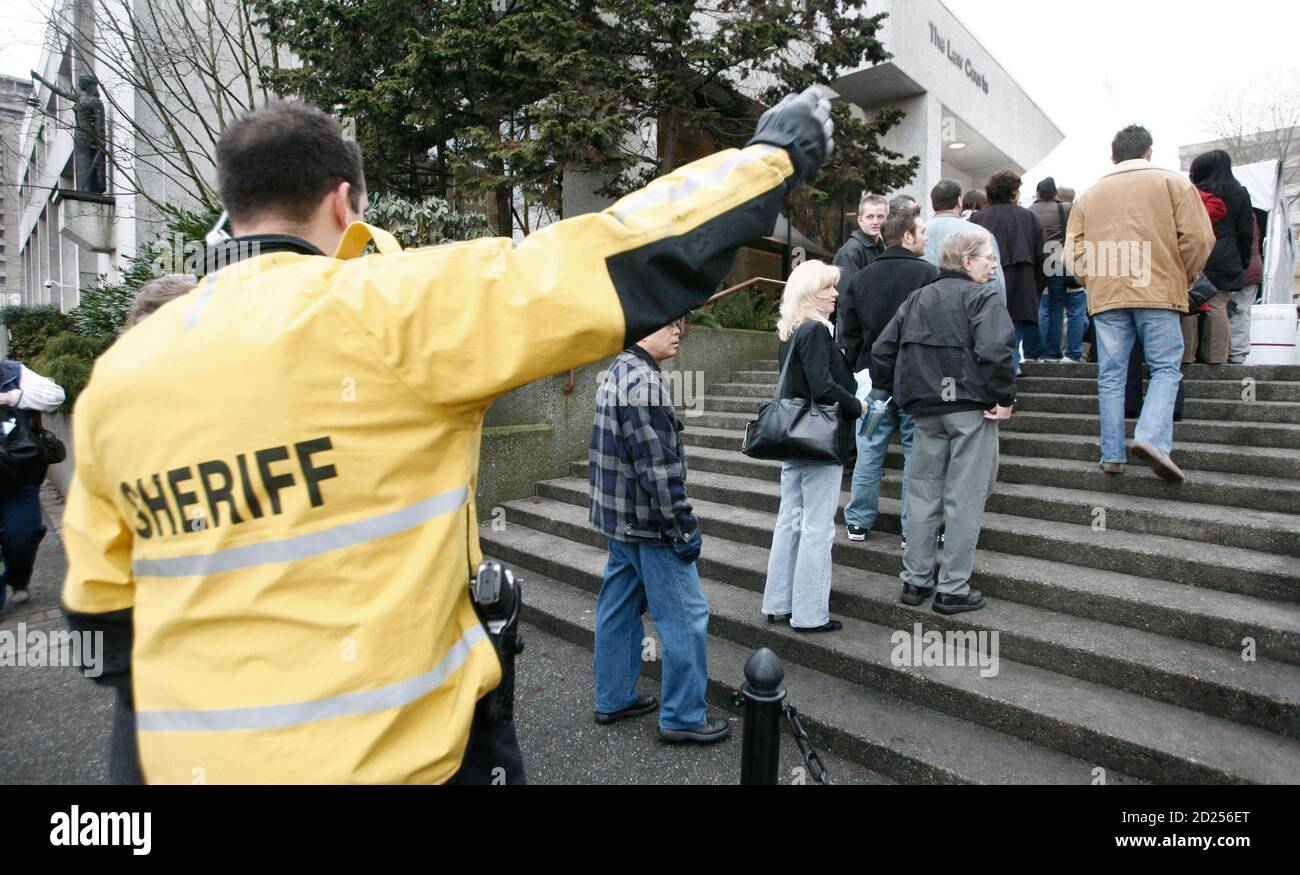 A sherriff directs potential jury members outside the courthouse in New Westminister, British Columbia December 9, 2006. Some 600 potential jurors for the multiple murder trial of Robert Pickton had been summonsed for selection by the province's court services branch, four times the number sent out for a regular trial. Pickton's trial is scheduled to begin January 8, 2007.      REUTERS/Andy Clark (CANADA) Stock Photo