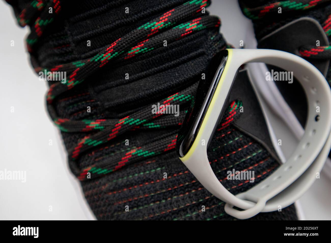 Fitness band bracelet and black fashion sneakers. Closeup, selective focus Stock Photo