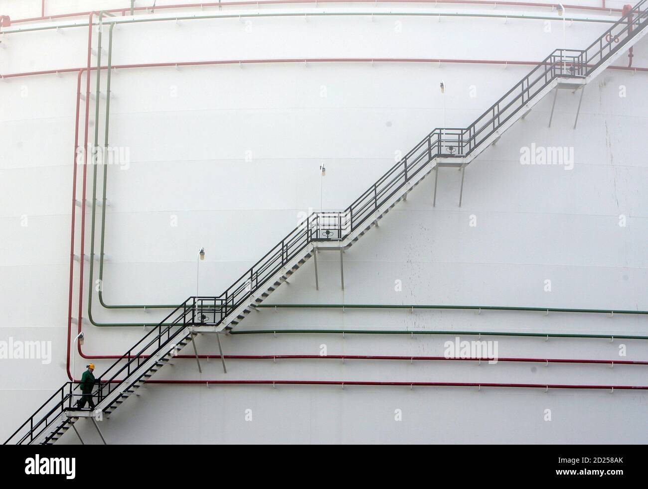Worker walks up to the oil storage tank at Hungarian oil and gas group MOL's main Duna (Danube) refinery in Szazhalombatta, 20km (12 miles) south of Budapest, in this January 8, 2007 file photo. Hungarian oil firm MOL spurned what it said was a hostile approach from Austrian rival OMV and on Monday presented new financial targets which it said proved it was on track for growth.REUTERS/Laszlo Balogh/File (HUNGARY) Stock Photo