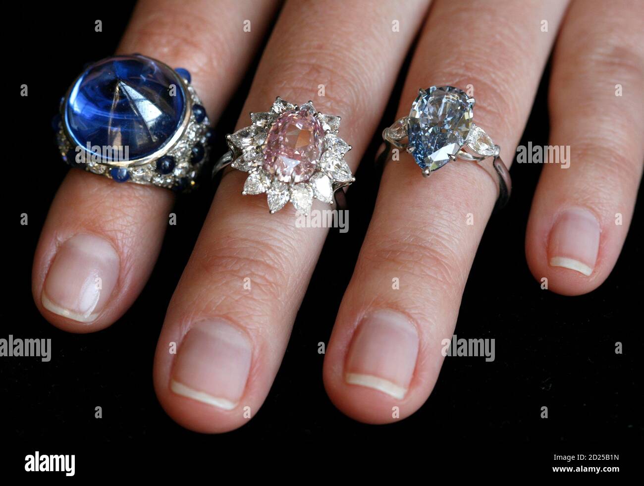 A model displays a cabochon sapphire-set ring dating form 1930 (L) a fancy vivid purplish pink diamond ring (C) and a fancy vivid blue pear-shaped diamond during a preview at Sotheby's auction house in Geneva May 7, 2008. These jewels are expected to reach between $ 20,000 and $ 30,000, between $ 2,350,000 and $ 2,850,000 and between $ 2,800,000 and $ 3,500,000 during an auction sale in Geneva May 15.   REUTERS/Denis Balibouse   (SWITZERLAND) Stock Photo