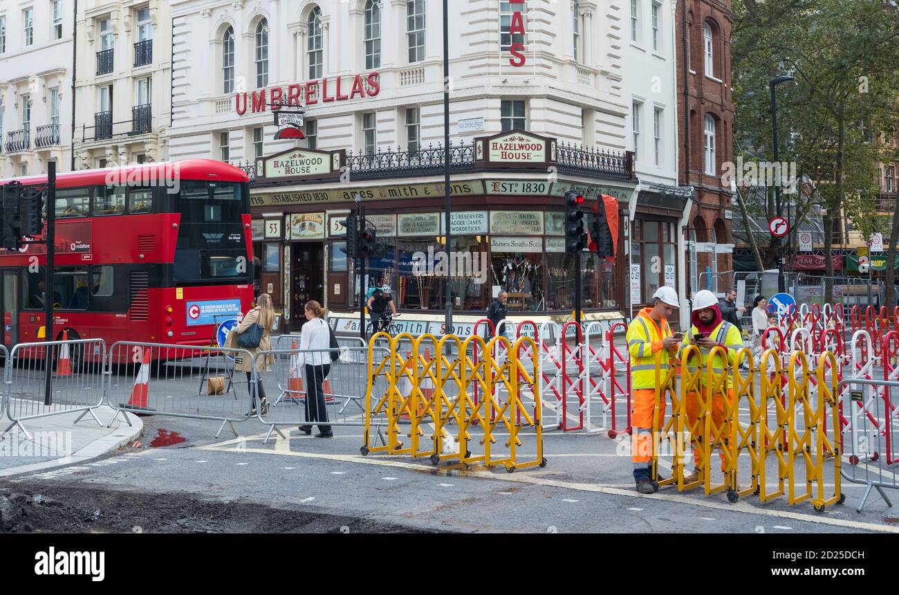 Workmen on their phones, New Oxford Street, London Stock Photo