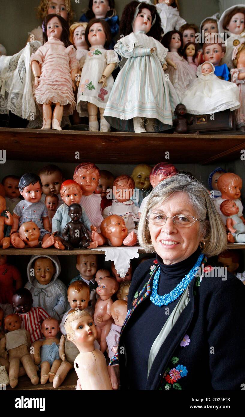 Manuela Cutileiro, who runs the Doll Hospital, poses for a portrait in  front of repaired dolls at the hospital in Lisbon December 17, 2009. The  sign "Doll Hospital, 1830" above a doorway