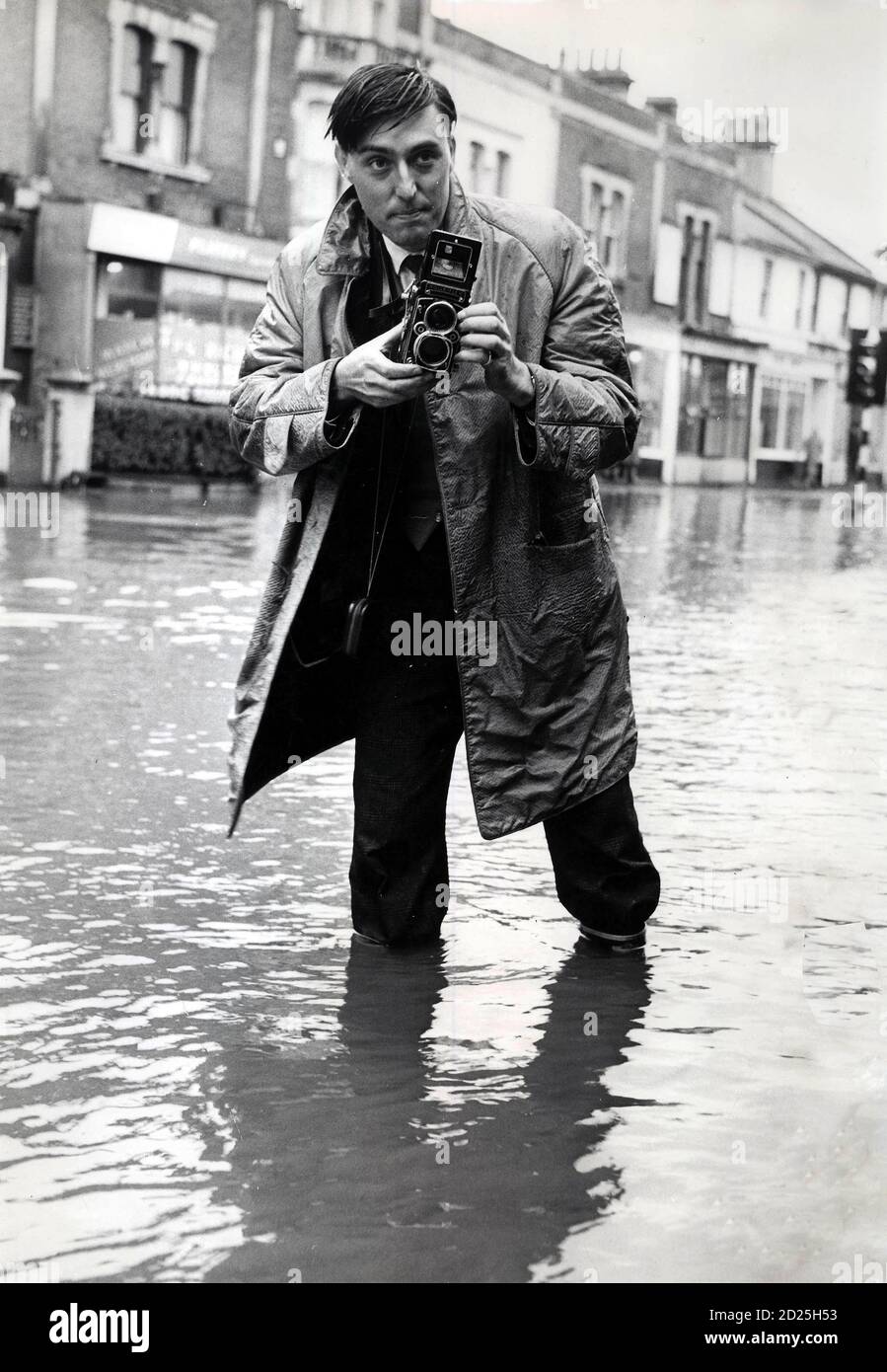 A press photographer using a Rolleiflex camera in the 1960s during a flood in Bath, Avon Stock Photo