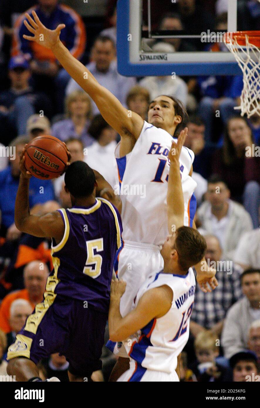 University of Florida Joakim Noah (13) and Lee Humphrey (12) prepare to  block the shot by Prairie View Derek Noore (5) in the first half of their  NCAA basketball game in Gainesville,
