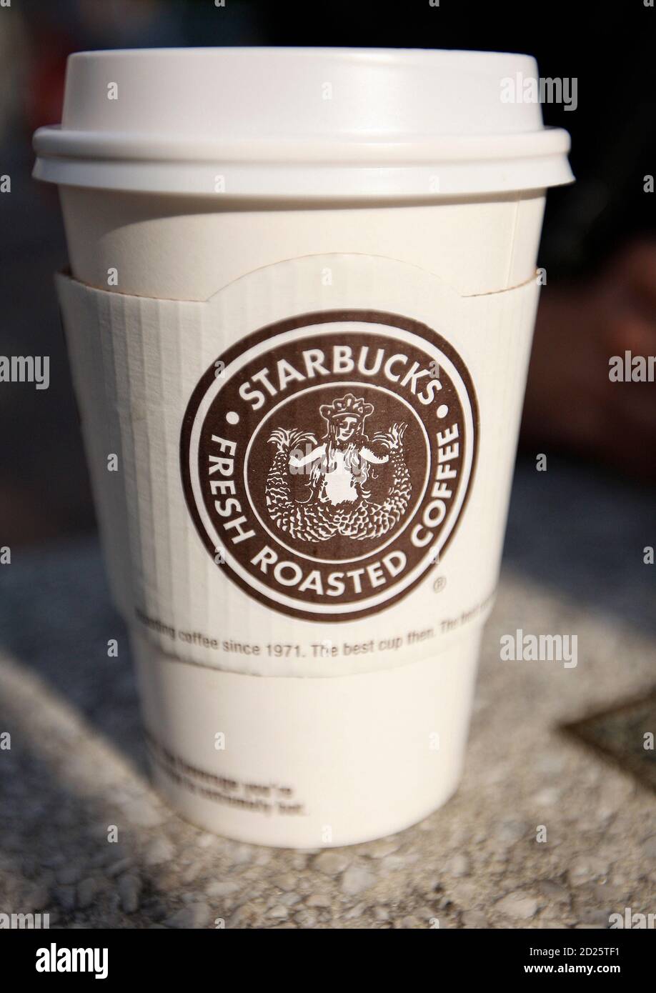 A Starbucks coffee cup sits on a table in New York July 3, 2008. Coffee  seller Starbucks Corp said on Tuesday it plans to close 600 underperforming  U.S. stores and cut up