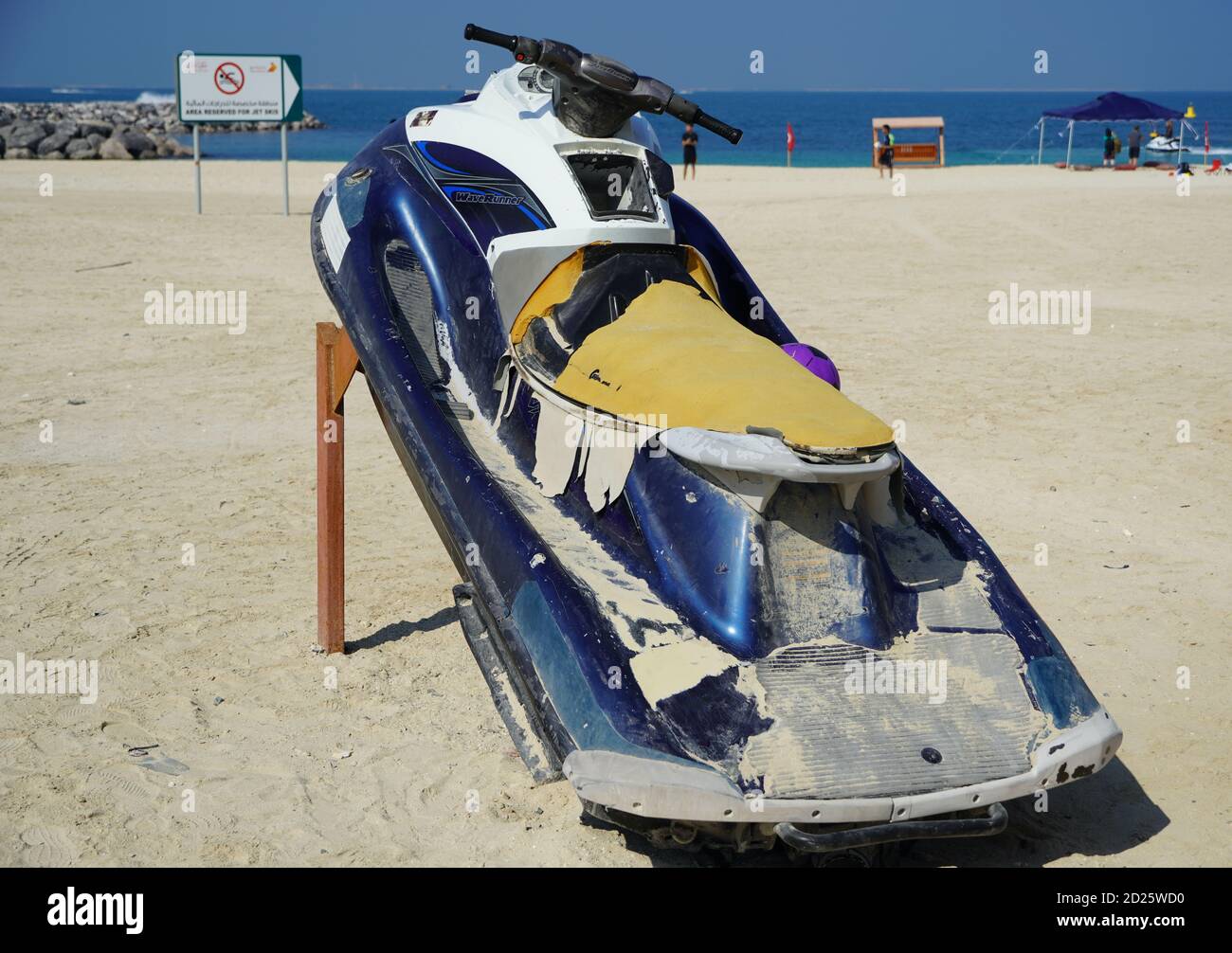 Dirty Old Jet Ski Parked On The Beach Of Holiday Season. Old Jet Skis On The Beach On Wooden Trailer. Blue And White Jet Ski - Dubai Uae January 2020 Stock Photo