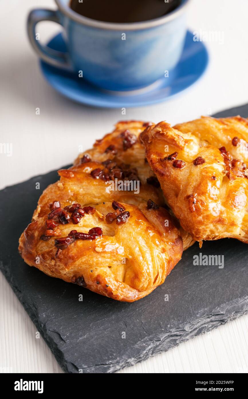 Pastries on blackboard next to cup of coffee and white background Stock Photo