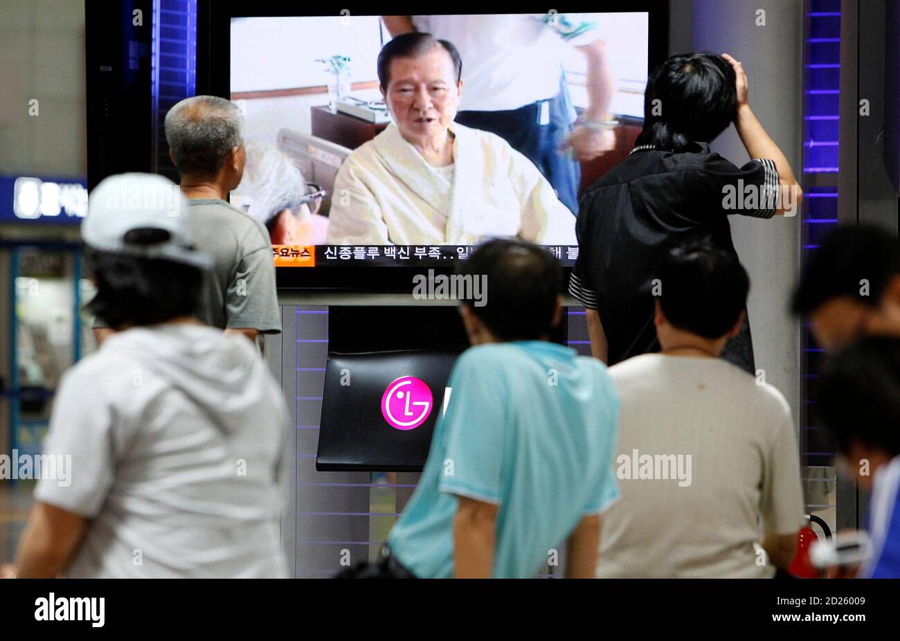 People watch the news on former South Korean President Kim Dae-jung's death at the Seoul railway station August 18, 2009. Former South Korean President Kim, a towering figure in South Korea's struggle for democracy who won the 2000 Nobel Peace Prize for seeking rapprochement with the communist North, died on Tuesday at the age of 85. An official at a Seoul hospital treating Kim for pneumonia confirmed the death.  REUTERS/Jo Yong-Hak (SOUTH KOREA POLITICS OBITUARY) Stock Photo
