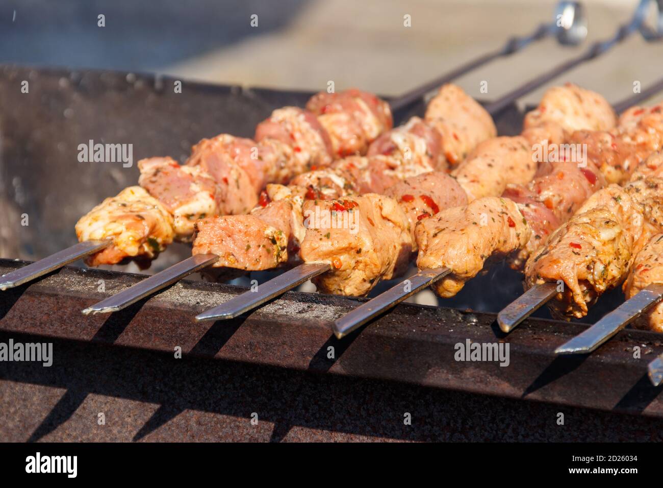 Grilled kebab cooking on metal skewer. Roasted meat cooked at barbecue