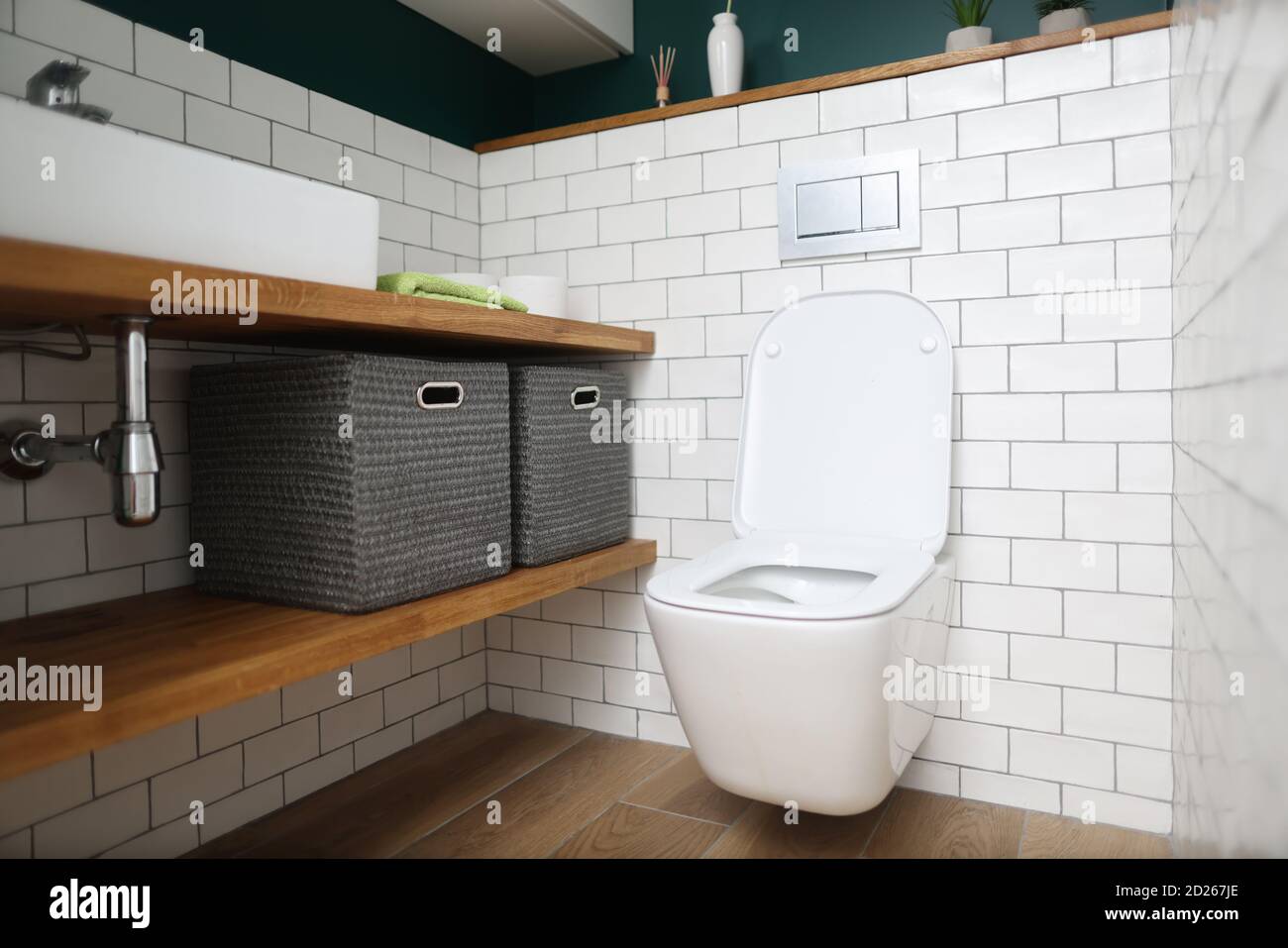 Toilet bowl, sink, shelves with boxes for storing things in toilet