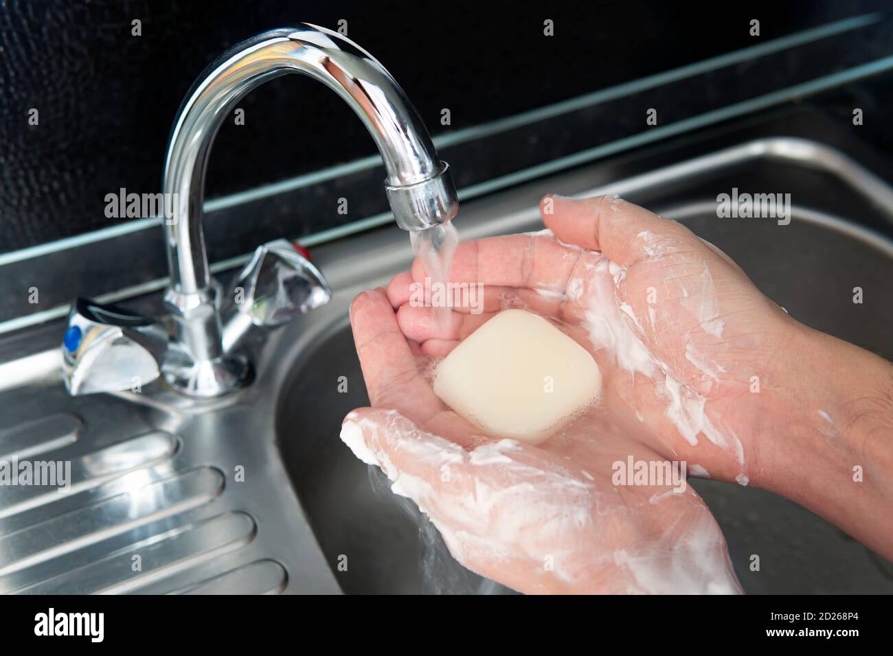 Моет глаза. Человек моет руки под краном. Мытье тела под краном. Моет руки мылом над металлической мойкой.