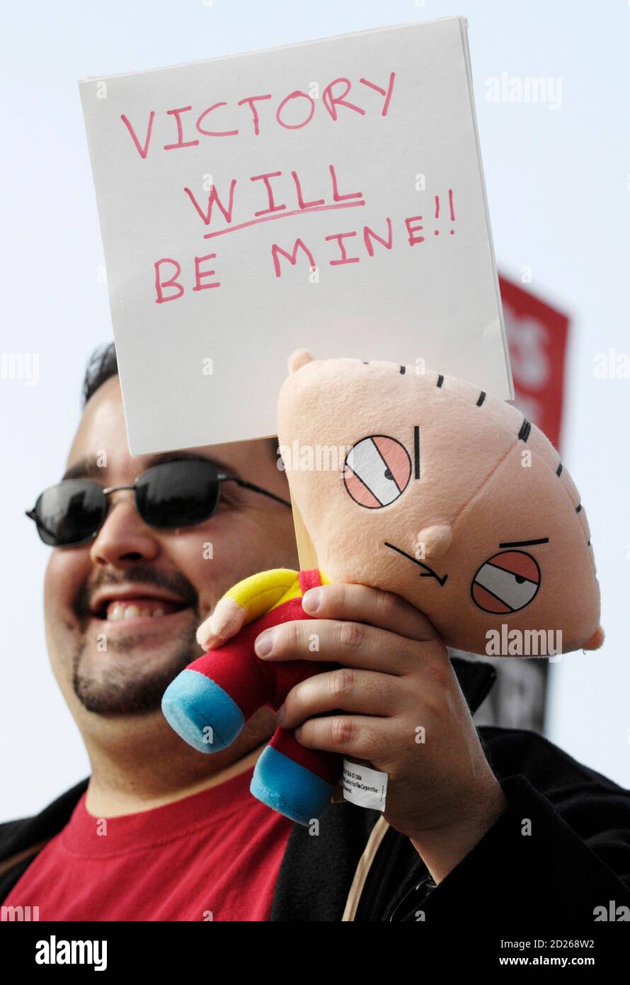 Writer Dan Garrett Of Los Angeles Holds A Doll Of Stewie Griffin From Family Guy As He Participates In A Strike By The Writers Guild Of America Outside The Fox Studio In