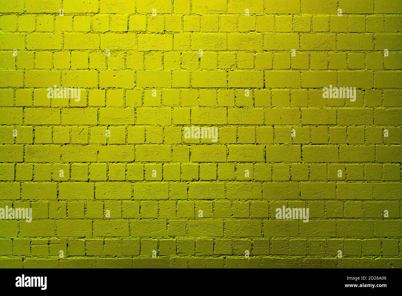 Yellow brick wall background with shades of light and dark yellow Stock