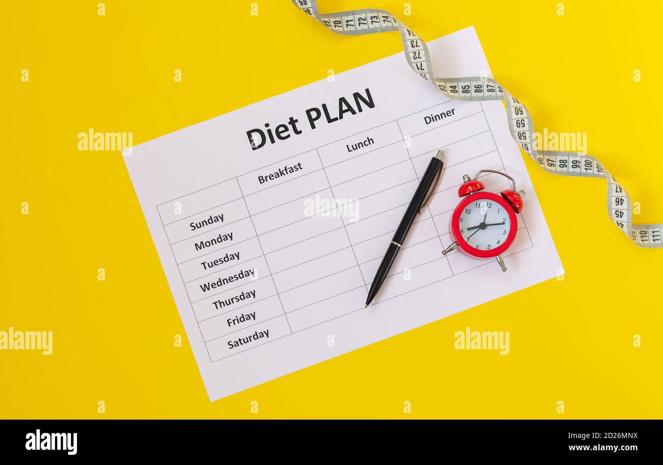 Diet schedule planner, measuring tape, pen and alarm top view. Time to start a diet concept Stock Photo