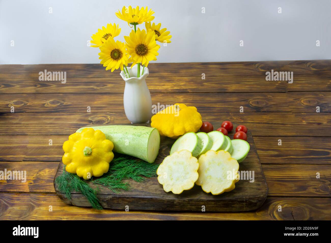 Zucchini and small yellow squash on a cutting board are sliced. Mono diet concept, healthy food. Selective focus, dark wooden background. Stock Photo