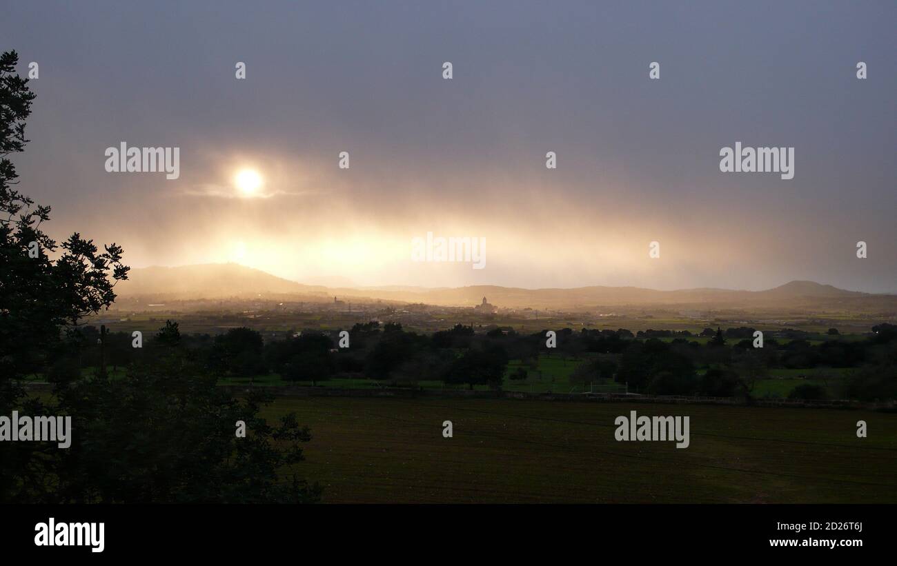 Sun over Petra in Mallorca on a rainy day Stock Photo