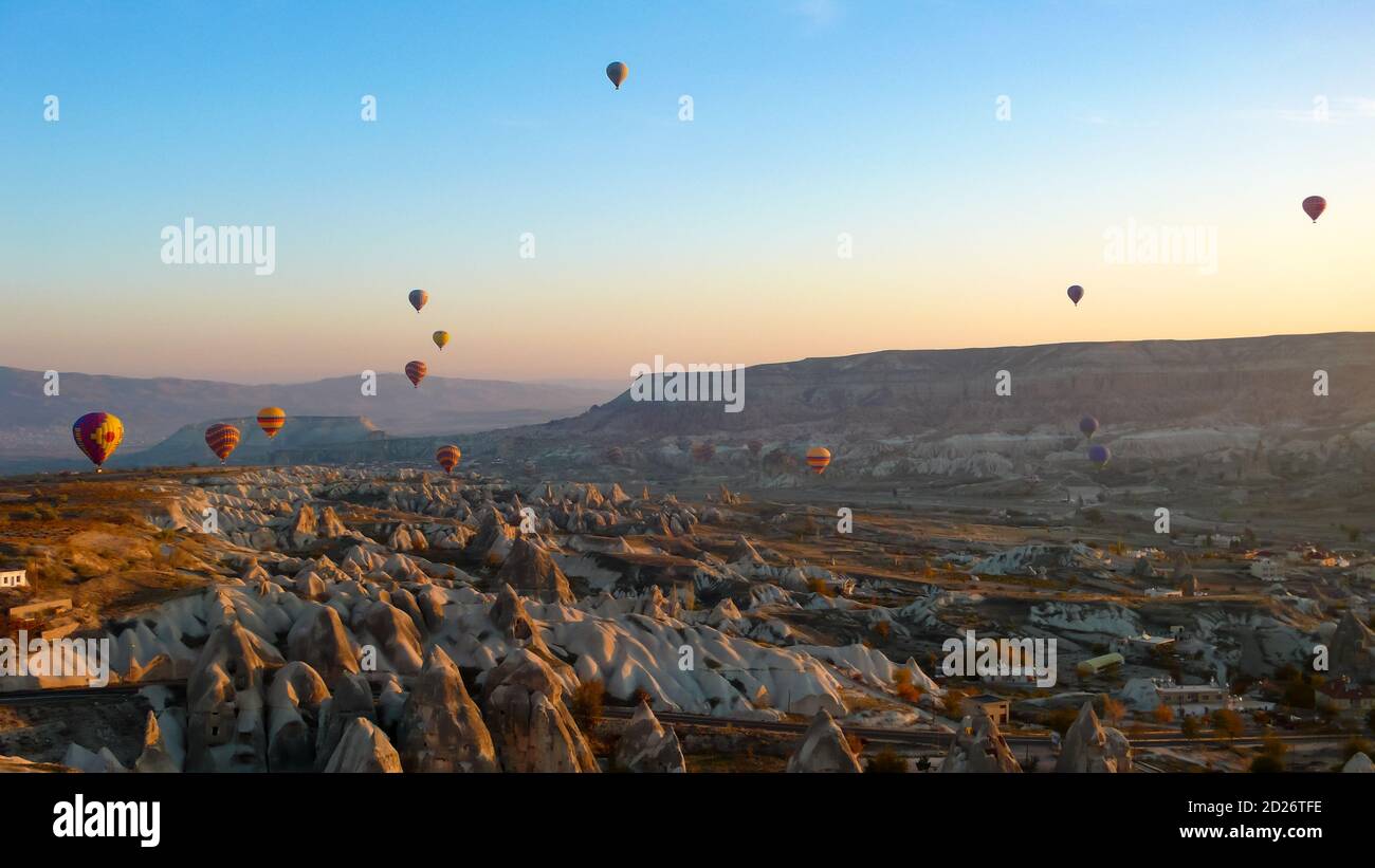 Balloons above Cappadocian fairy chimneys at sunrise Stock Photo - Alamy