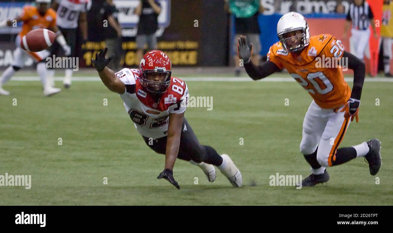 Calgary Stampeders' Nik Lewis tries to reach the ball in the endzone as BC  Lions' Reggie Myles looks on (R) during the second half of CFL play in  Vancouver, British Columbia August