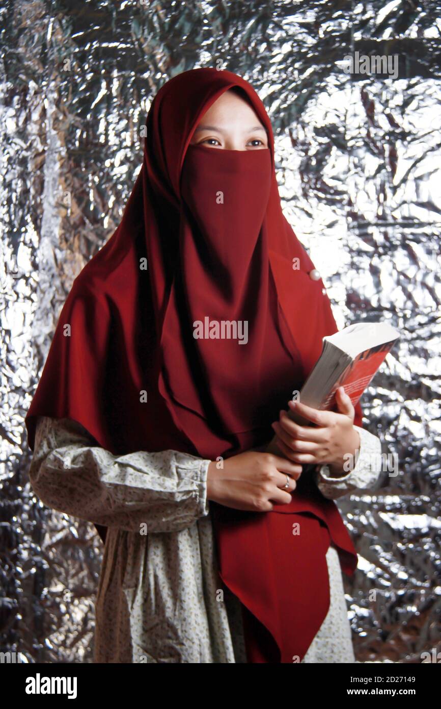 Veiled Model a portrait of a veiled Asian woman holding a book. beautiful Muslim ...