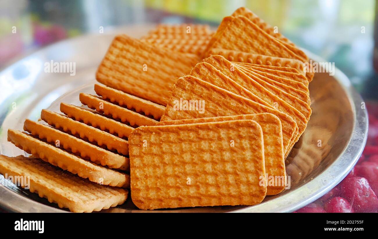 Wheat biscuits in the steel plate with blury background. Indian biscuits popularly known as Chai-biscuit in India Stock Photo
