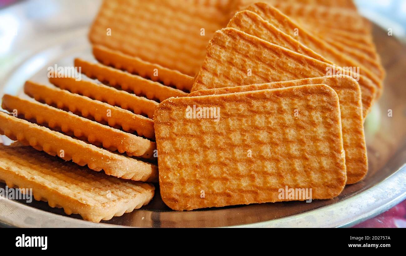 Wheat biscuits in the steel plate with blury background. Indian biscuits popularly known as Chai-biscuit in India Stock Photo