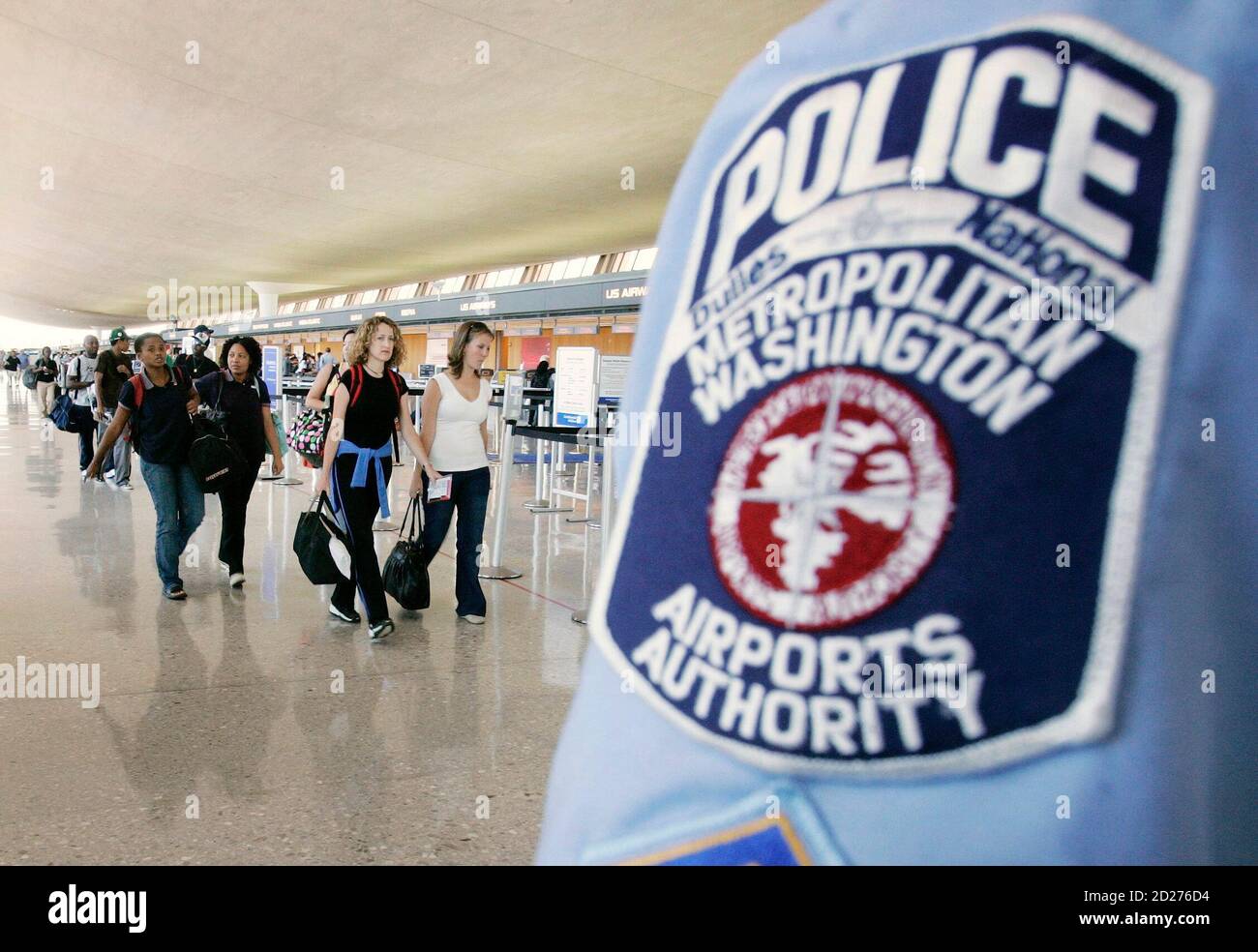 A Metropolitian Washington Airports Authority police officer keeps watch inside the departure terminal at Dulles International Airport outside Washington July 2, 2007.       REUTERS/Larry Downing   (UNITED STATES) Stock Photo
