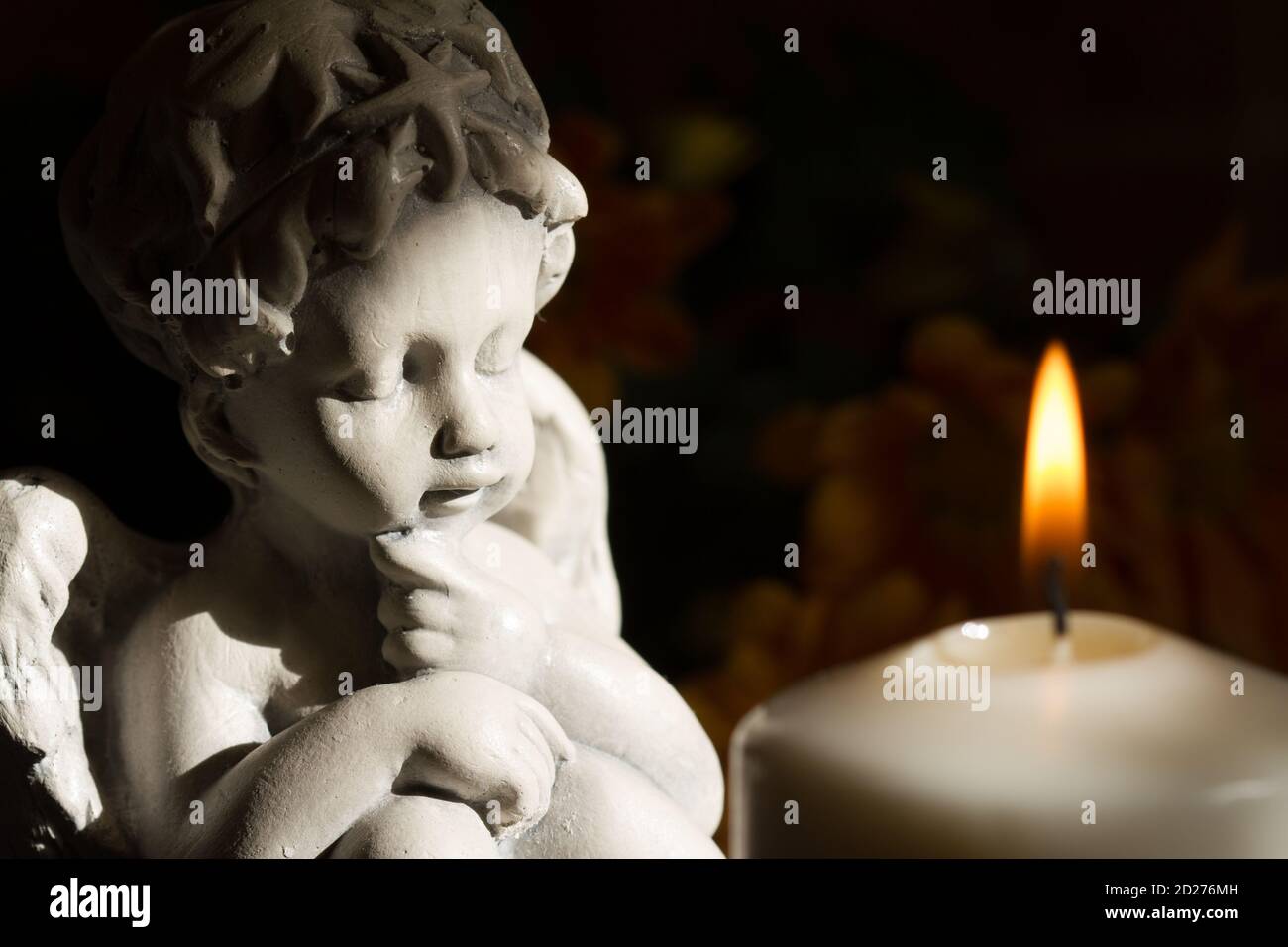Angel and burning candle on dark background Stock Photo