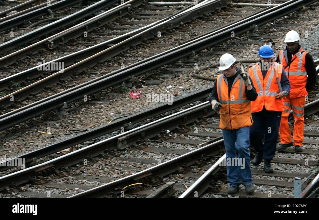 Network Rail workers walk along railway tracks in London February 28, 2008.  Britain's rail infrastructure firm Network Rail was fined 14 million pounds ($28 million) on Thursday over delays in track projects which disrupted New Year services.      REUTERS/Luke MacGregor   (BRITAIN) Stock Photo