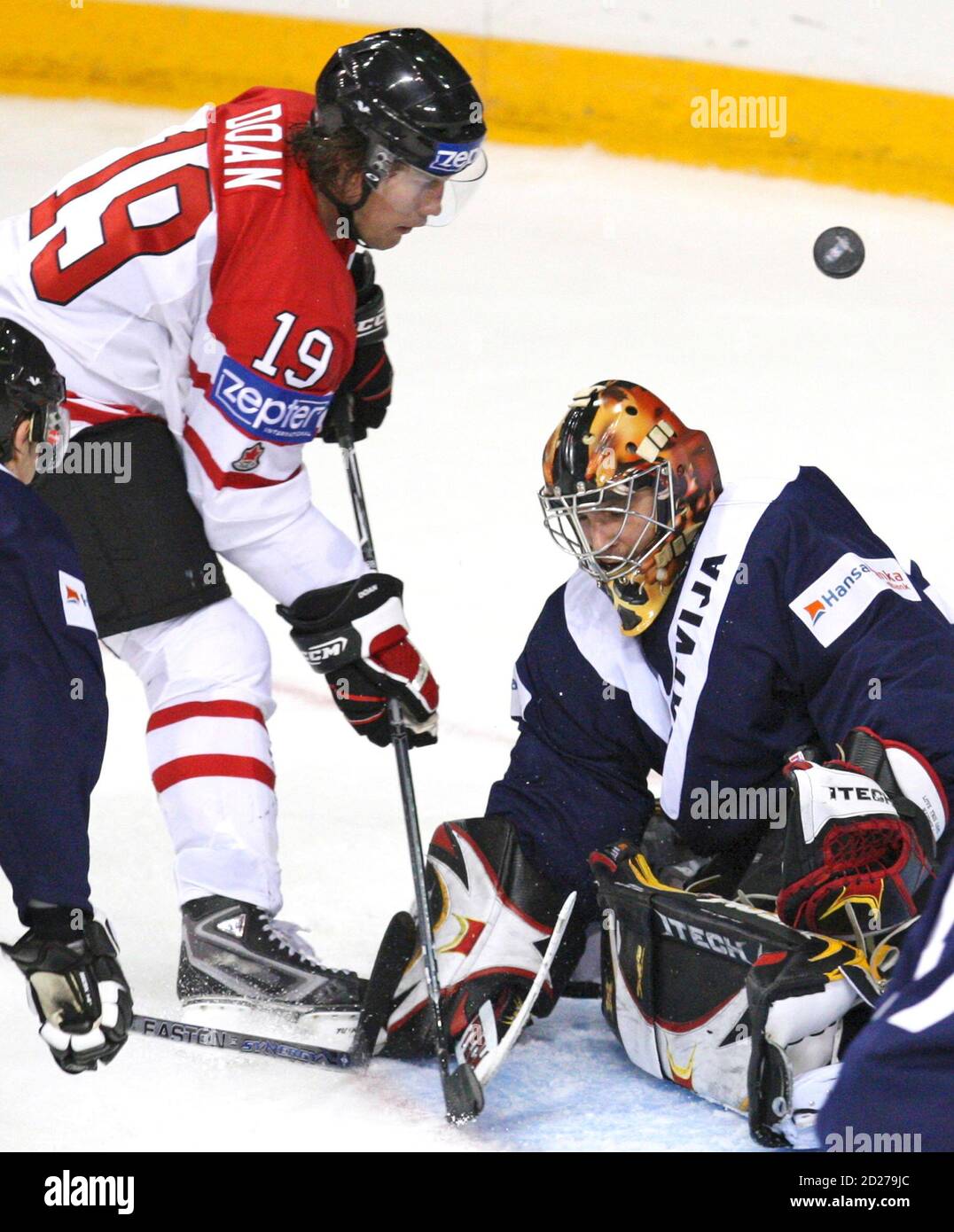 Latvia's goalie Sergejs Naumovs makes a save on Canada's Shane Doan (L)  during the third period