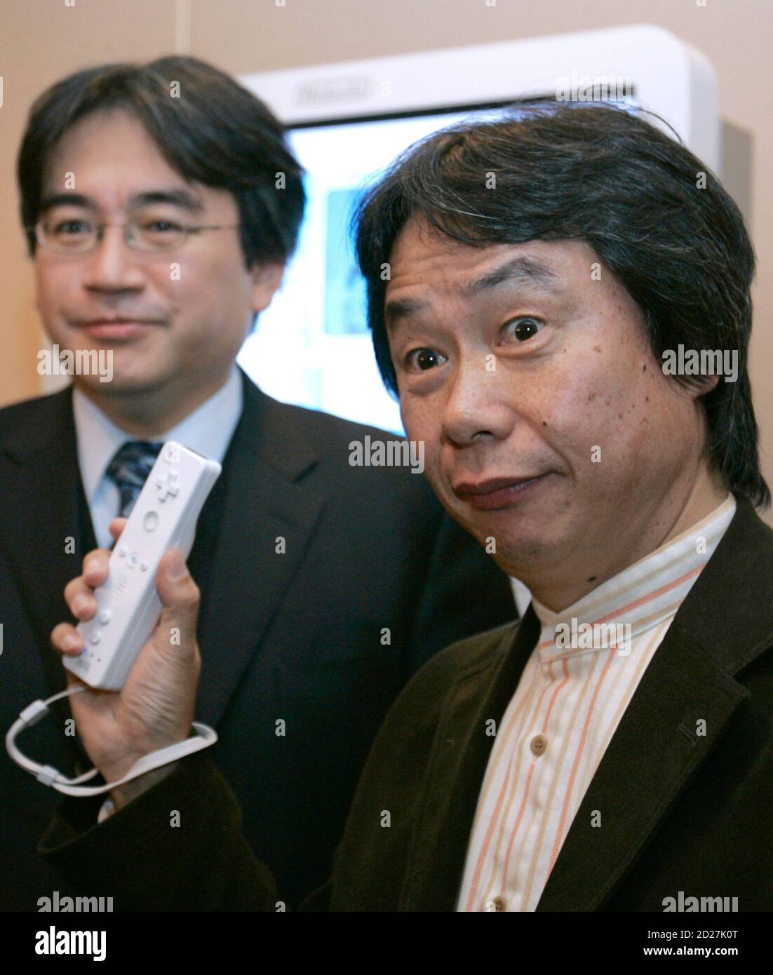 Japanese video game maker Nintendo Co's senior managing director and  "Mario" creator Shigeru Miyamoto (R) holds the new Wii game console  controller next to president Satoru Iwata during a news conference in