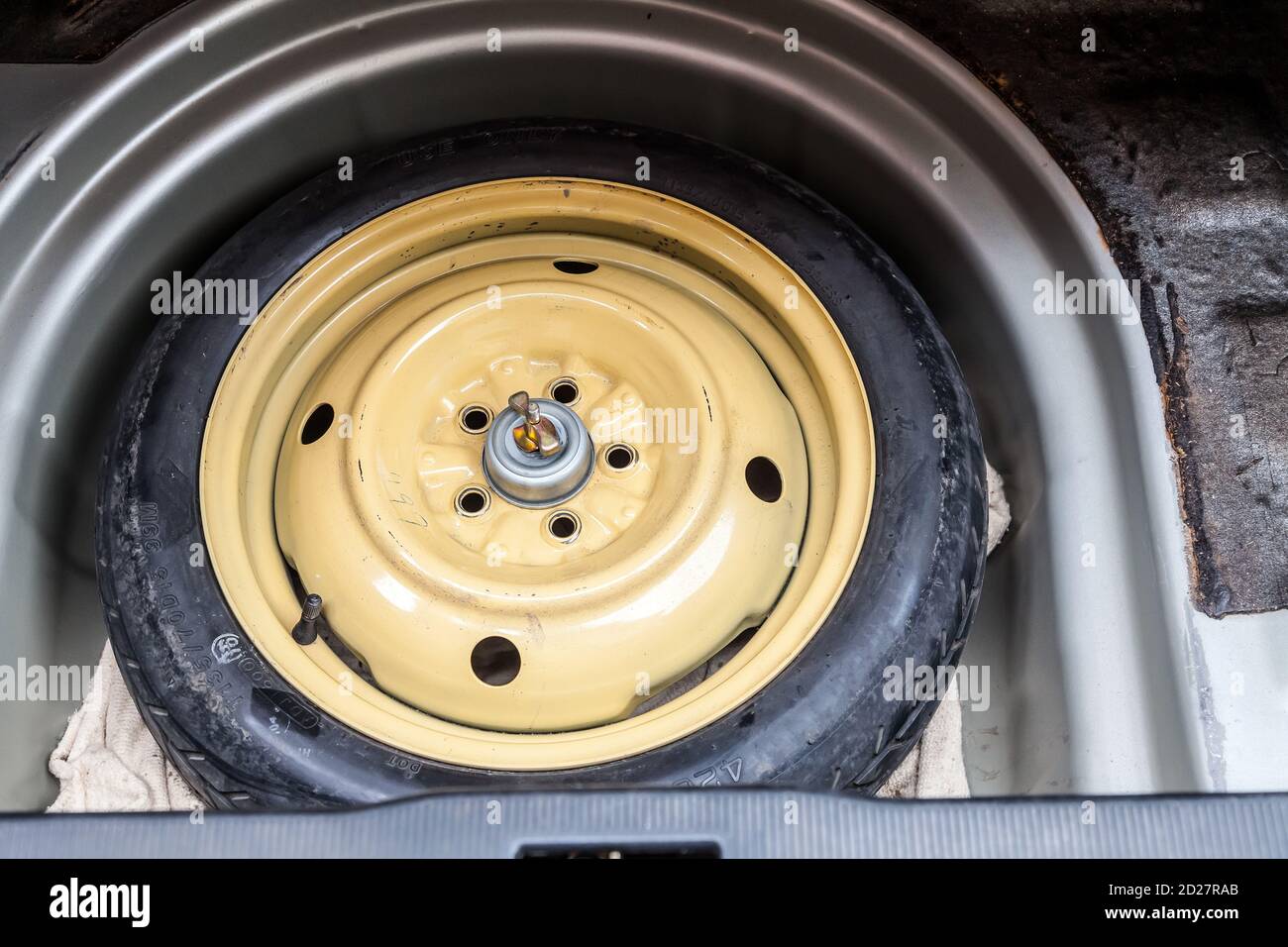 Car spare wheel tire in the trunk of the used car. Auto service