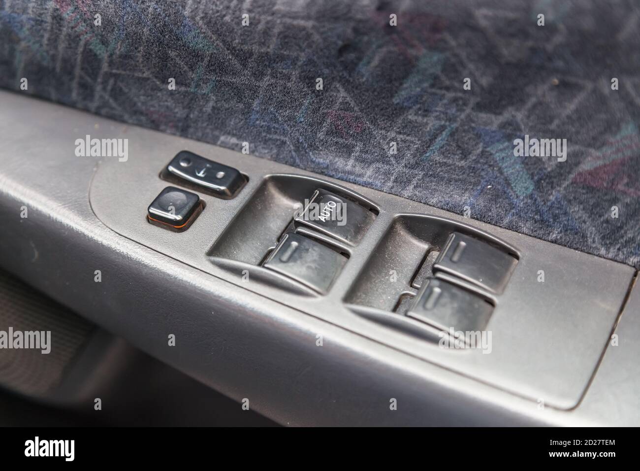 The driver's door is inside, with buttons for operating and raising the windows on a plastic armrest panel, trimmed in black and gray fabric for comfo Stock Photo