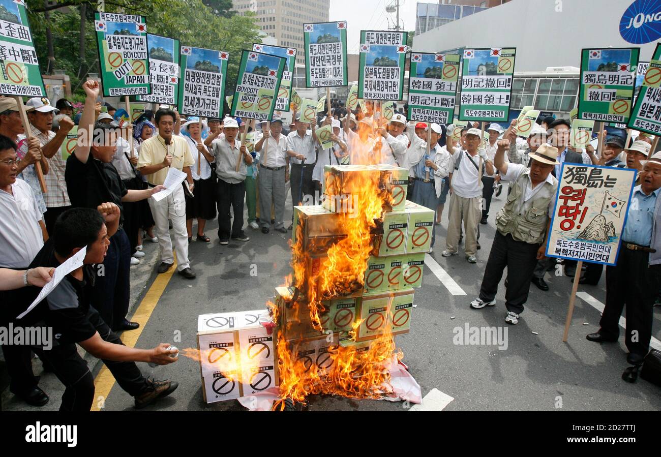 Protesters burn signs representing Japan's middle school teaching guide at a demonstration denouncing Japan's sovereignty claim over a group of desolate volcanic islets Seoul and Pyongyang call Dokdo and Tokyo calls Takeshima, in front of the Japanese embassy in Seoul July 15, 2008. South Korea's coastguard said on Tuesday it had stepped up patrols near the islands, a day after Seoul recalled its ambassador in anger at new Japanese claims to the rocky outcrops. On Monday, Tokyo said it had told Seoul that it would refer in a middle school teaching guide to the islands as Japanese territory. Th Stock Photo