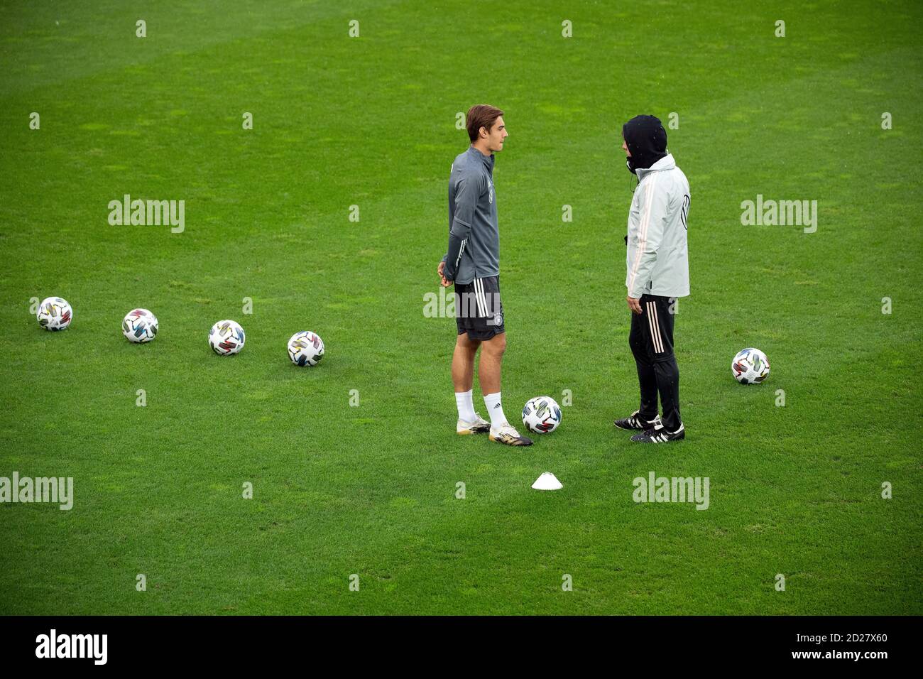 Cologne, Germany. 06th Oct, 2020. Football: national team, the day before the international test match against Turkey. National coach Joachim Löw (r) talks to Florian Neuhaus during the training of the national team in the RheinEnergie stadium. Credit: Federico Gambarini/dpa - IMPORTANT NOTE: In accordance with the regulations of the DFL Deutsche Fußball Liga and the DFB Deutscher Fußball-Bund, it is prohibited to exploit or have exploited in the stadium and/or from the game taken photographs in the form of sequence images and/or video-like photo series./dpa/Alamy Live News Stock Photo