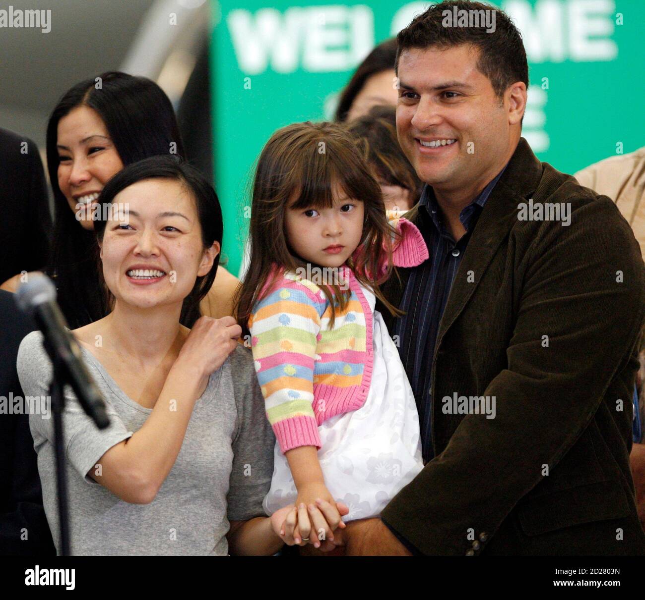 Freed Current TV journalist Euna Lee (behind microphone) smiles after being  reunited with her husband Michael Saldate (R) and daughter Hana Saldate in  Burbank, California, August 5, 2009. Lee and fellow journalist