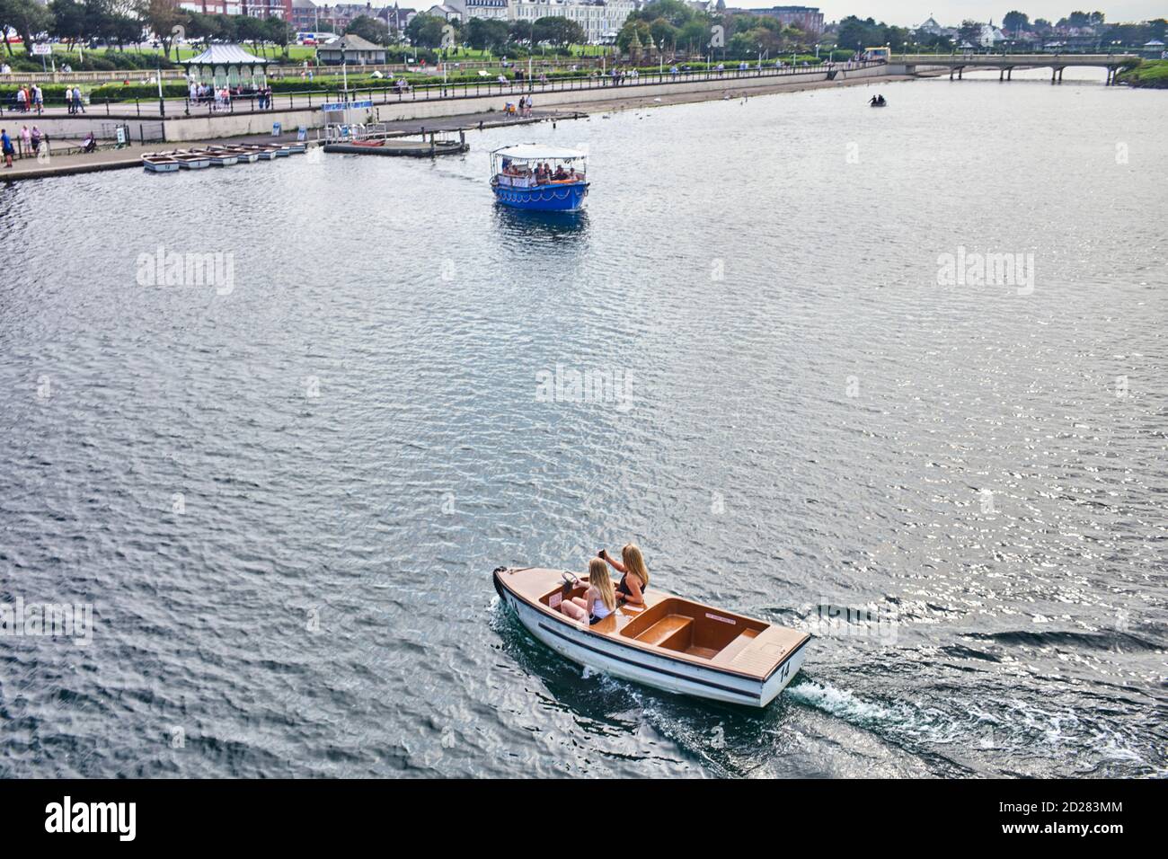 Two younger women in a hire motor boat at Southport Stock Photo