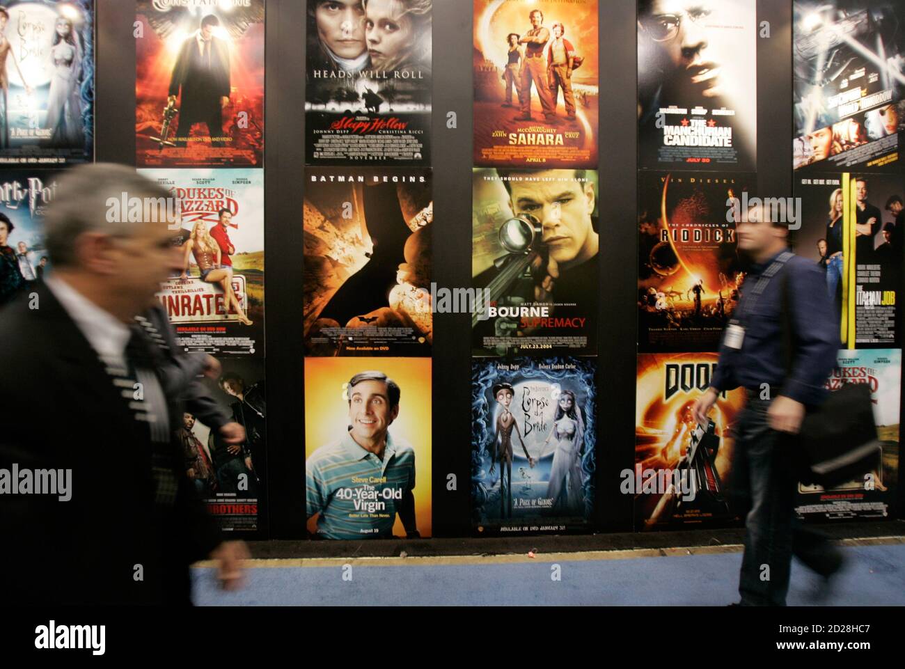 People walk by movie posters showing films available on the HD DVD format at the 2006 Consumer Electronics Show in Las Vegas January 6, 2006. The show is expected to attract 130,000 industry professionals. REUTERS/Rick Wilking Stock Photo