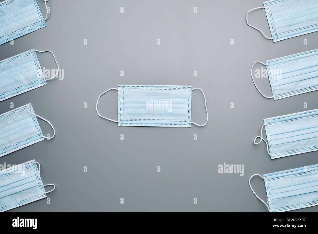 Top view background composition of medical masks laid out in pattern over grey background, copy space Stock Photo