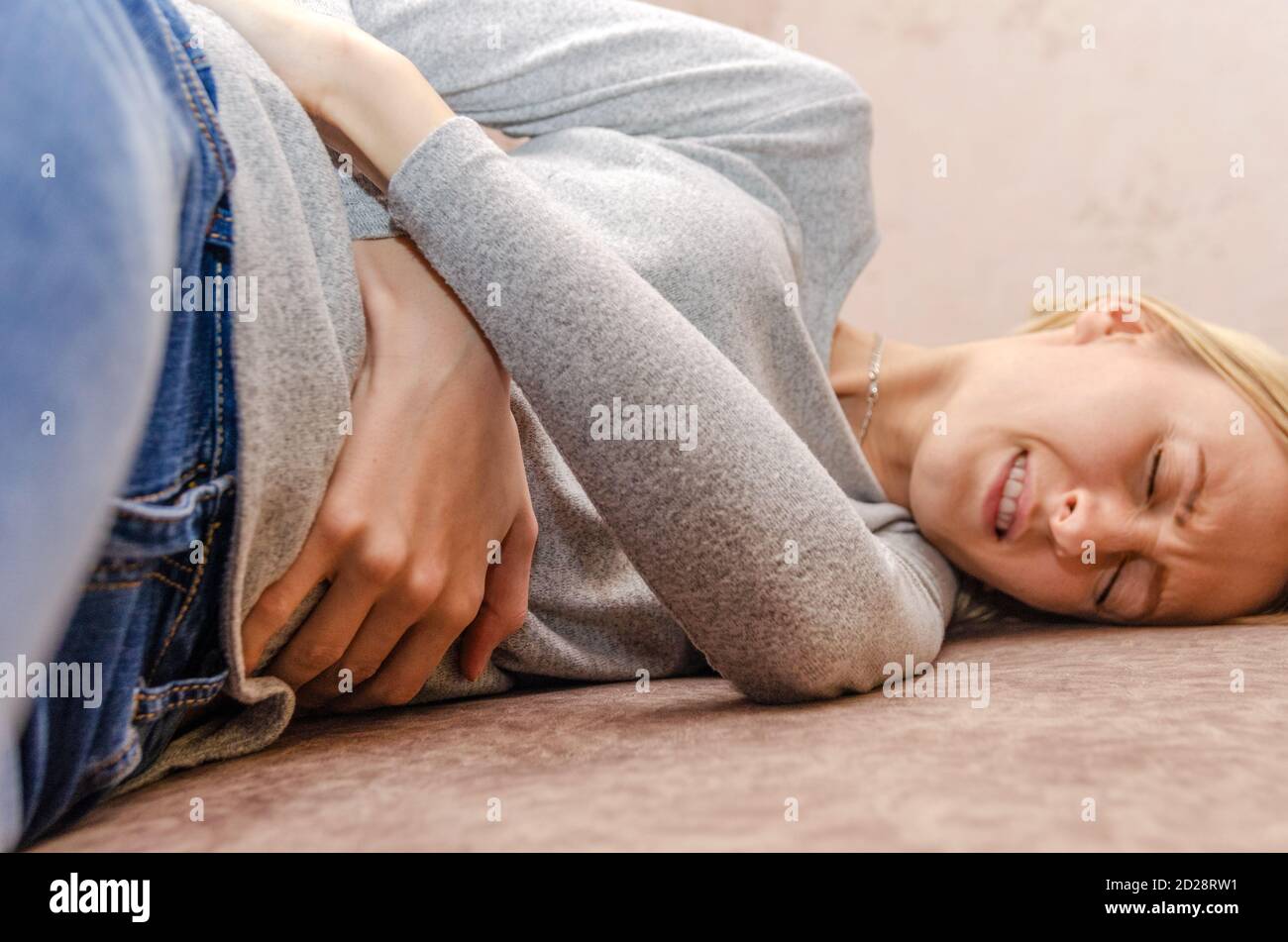 Blue jeans sweaters and a bra lying on a bed Stock Photo - Alamy