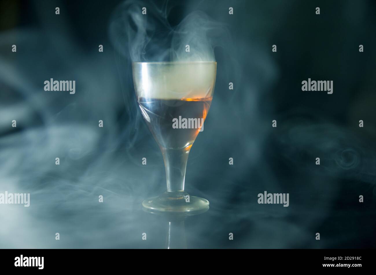 glass of cognac in the smoke on a black background Stock Photo