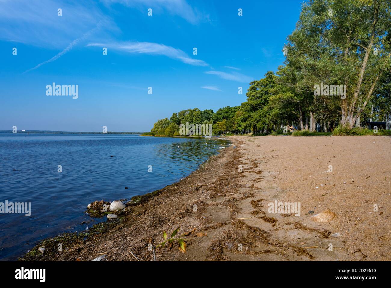 A sandy beach at a beautiful lake. Blue sky and water in the background ...