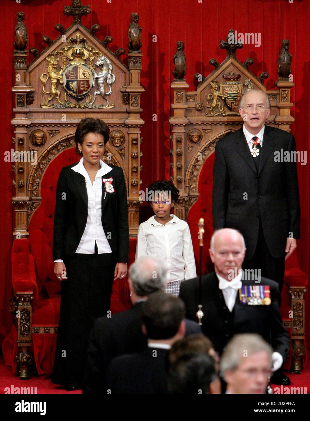 Newly sworn-in Canadian Governor General Michaelle Jean (L) stands with her  daughter Marie-Eden and husband Jean-Daniel Lafond for the national anthem  during a swearing-in ceremony on Parliament Hill in Ottawa September 27,