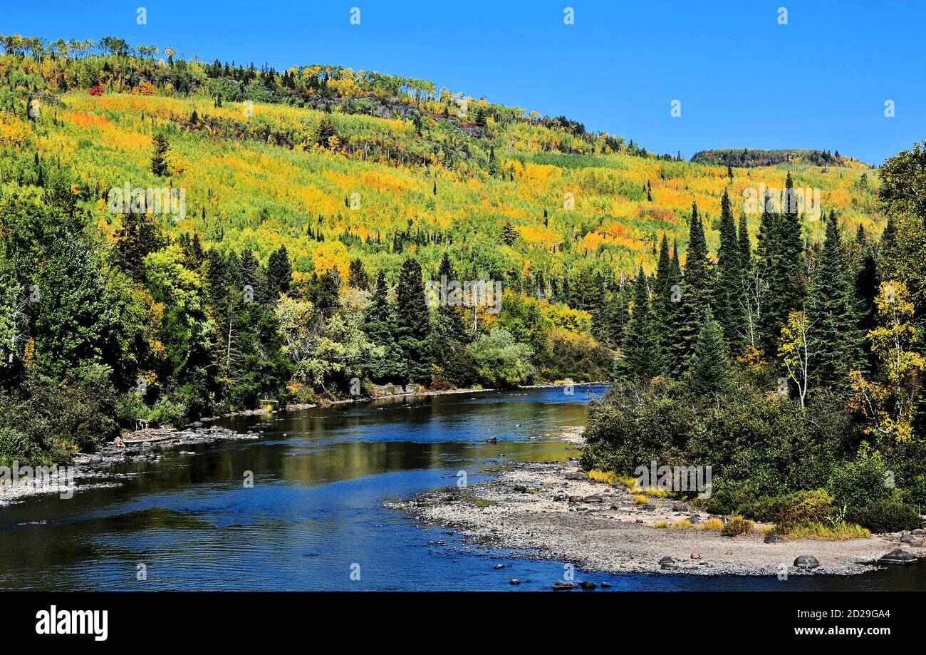 Pigeon River just below Middle Falls, with hills showing fall colors in Northwestern Ontario, Canada Stock Photo