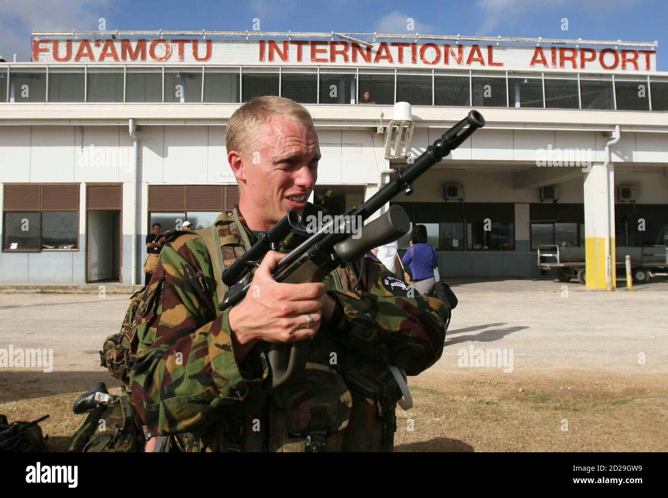 An unidentified New Zealand soldier checks his weapon after arriving at Fua'amotu Airport, Nuku