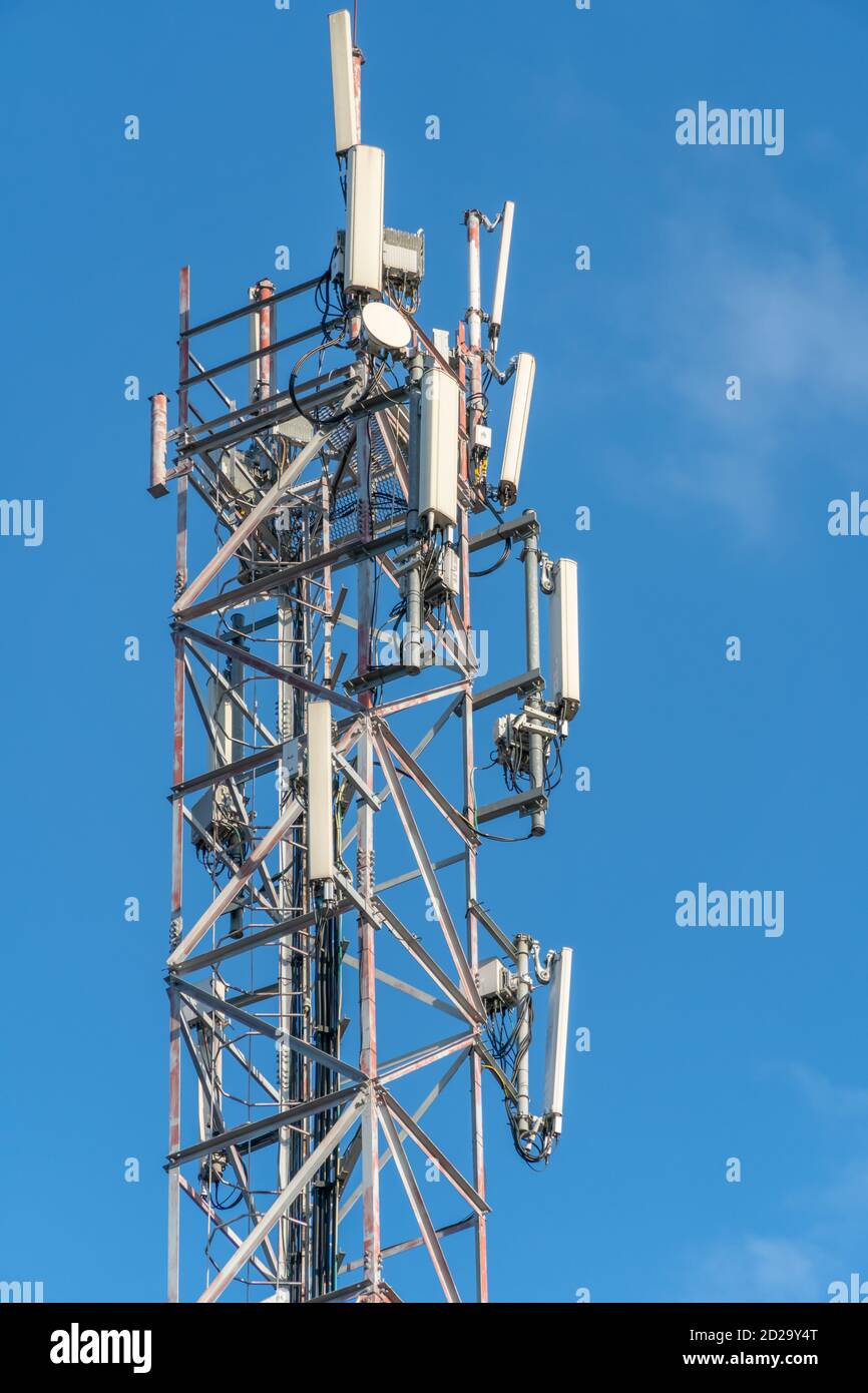 Mobile communication tower close-up against the blue sky, vertical photo Stock Photo